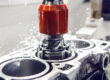 Close-up of honing stones creating a precise crosshatch pattern inside an engine block bore during cylinder repair.